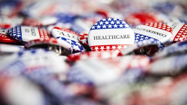 A pile of red, white and blue health care buttons.
