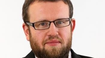 A bearded man wearing glasses and a jacket.