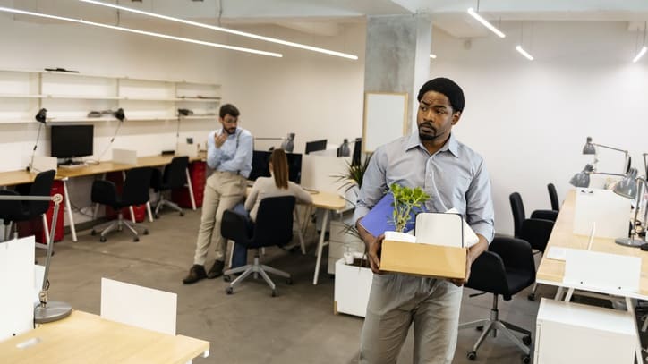 A man carrying a box in an office.