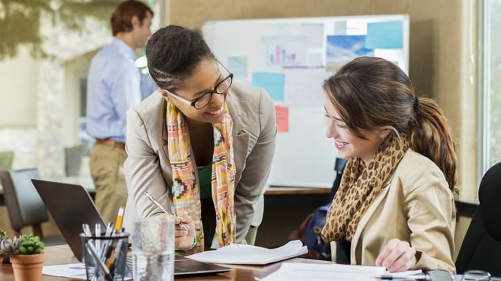 Two women working together in an office.