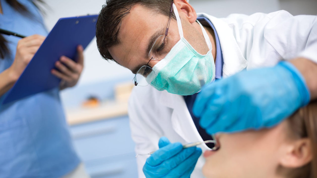 A dentist is examining a patient's teeth.