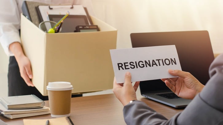 A man is holding up a sign that says resignation.