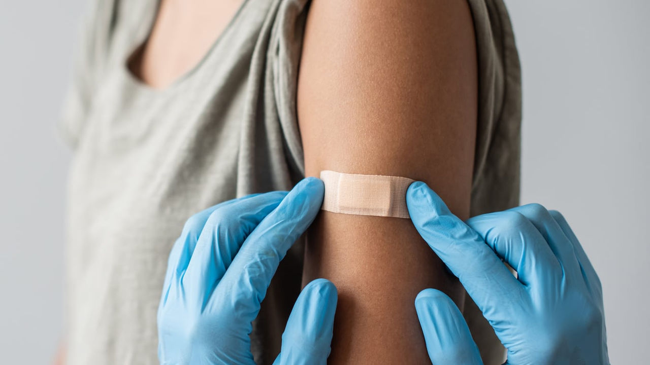 A woman is getting a vaccine on her arm.