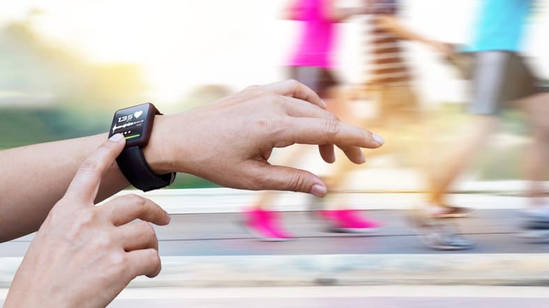 A person is running with a smart watch on their wrist.