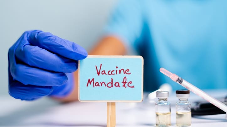 A person holding a sign with the word vaccine mandates