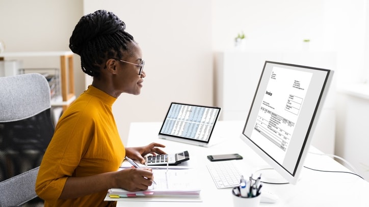 A woman working at her desk in front of a computer.