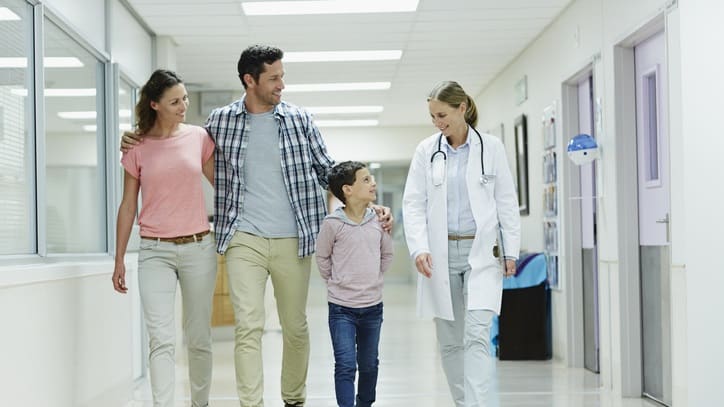 A family walking down a hospital corridor.