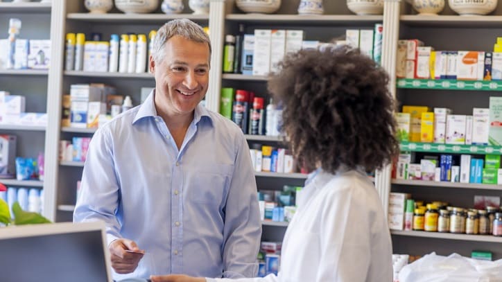A pharmacist talking to a customer in a pharmacy.