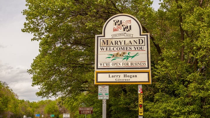 A sign for maryland in the middle of a wooded area.