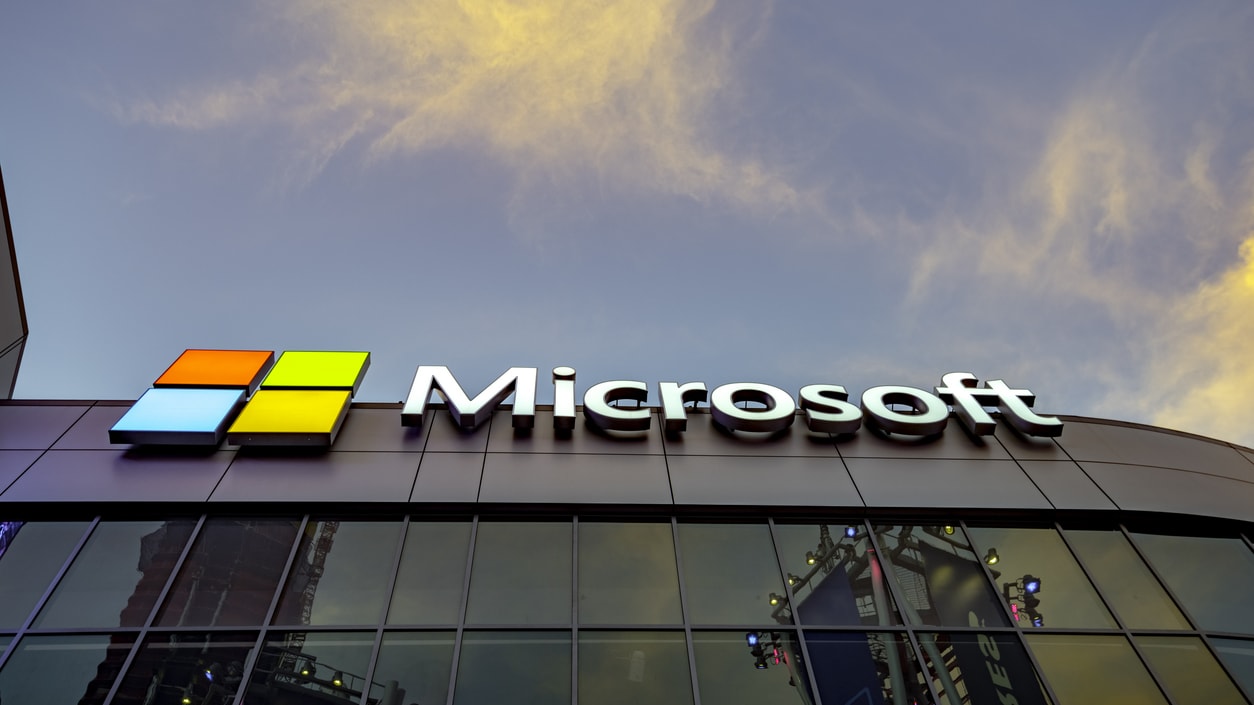 Microsoft logo in front of a building at dusk.
