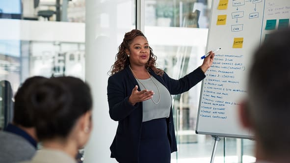 A businesswoman giving a presentation in a meeting room.