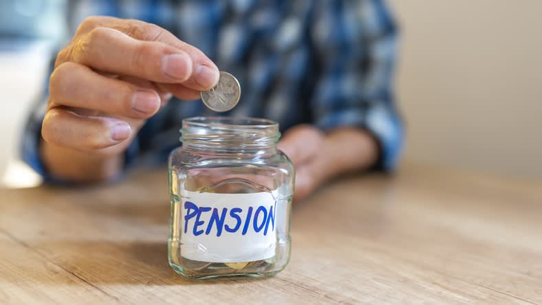 A man putting a coin into a jar with the word pension on it.