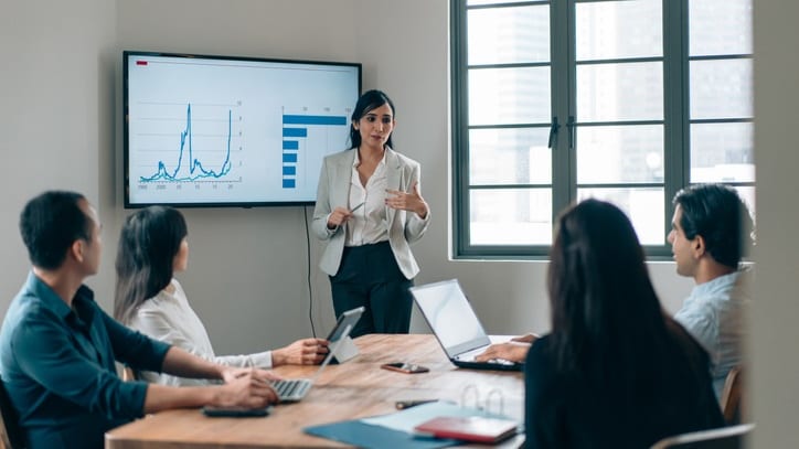 A woman giving a presentation to a group of people.