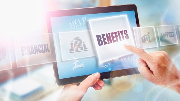 A hand holding a tablet with the word benefits on it.