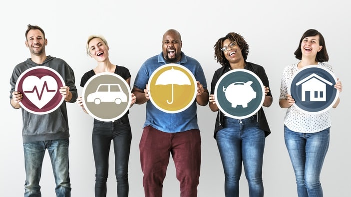 A group of people holding up signs with different types of insurance.