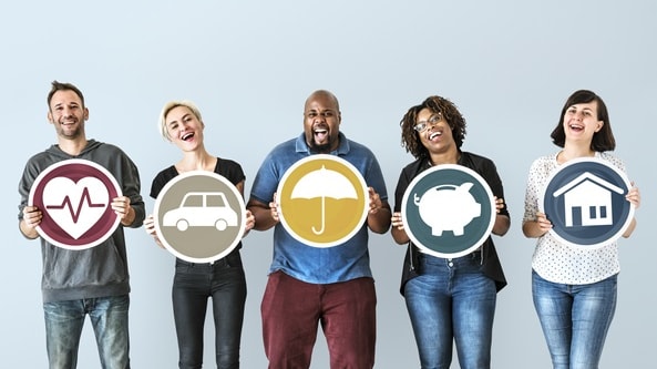 A group of people holding up signs with different types of insurance.