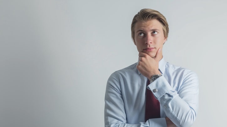 A young businessman with his hand on his chin.