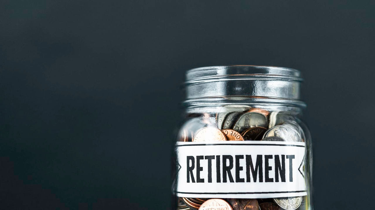 A jar full of coins with the word retirement on it.