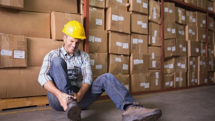 A man sitting on the floor in front of boxes.