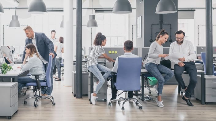 A group of people sitting at desks in an office.