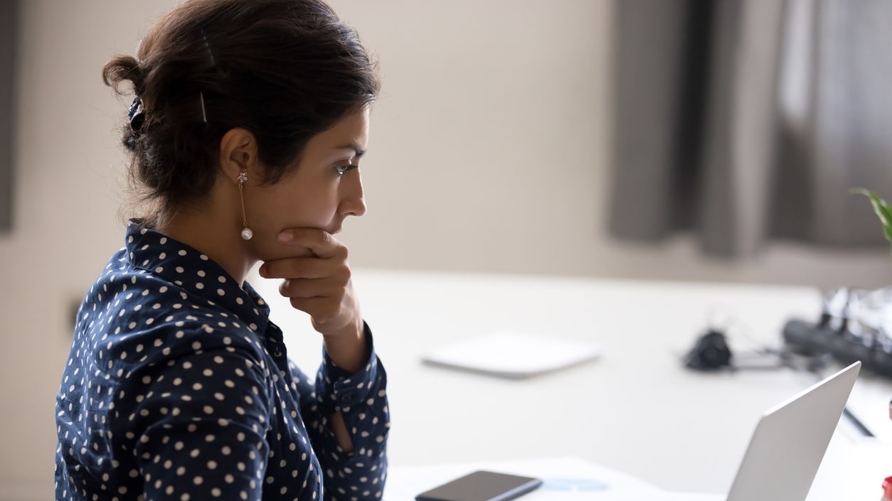 A woman sitting at a desk with a laptop in front of her.