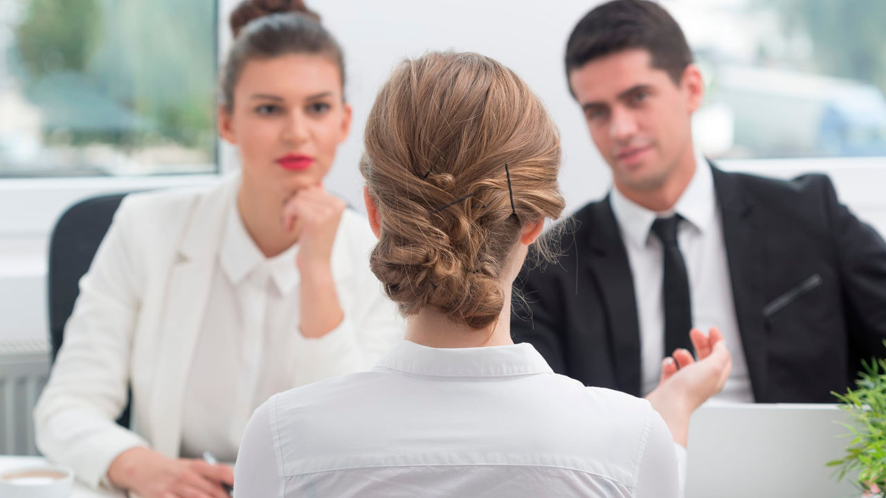 A woman is talking to a group of people in an office.