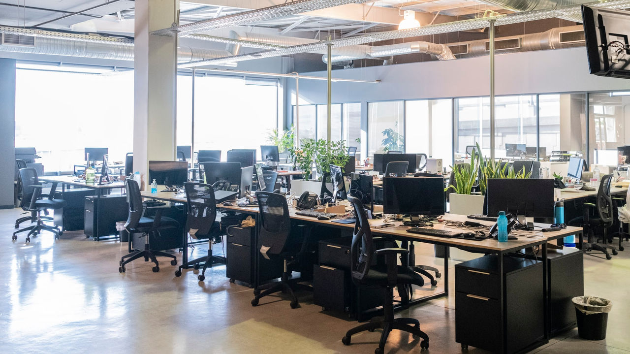 An empty office with many computers and desks.