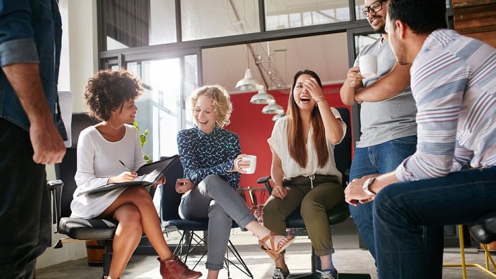 A group of people sitting around a table in an office.