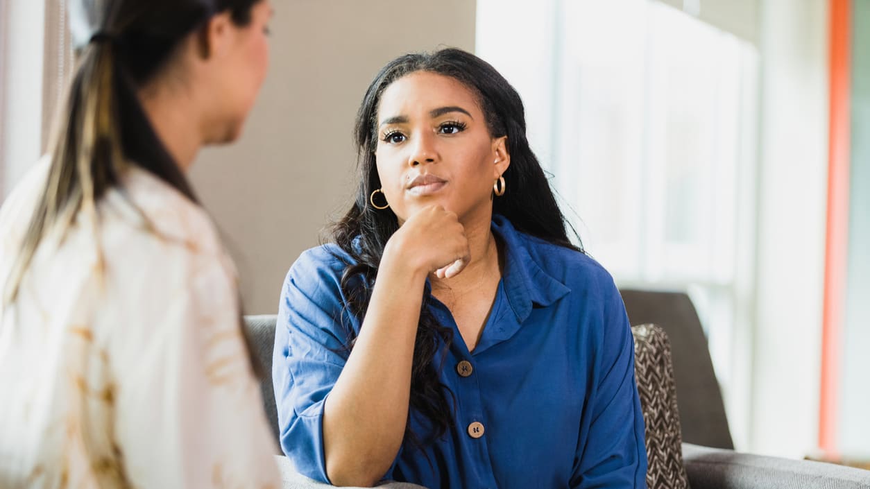 Two women talking to each other in an office.