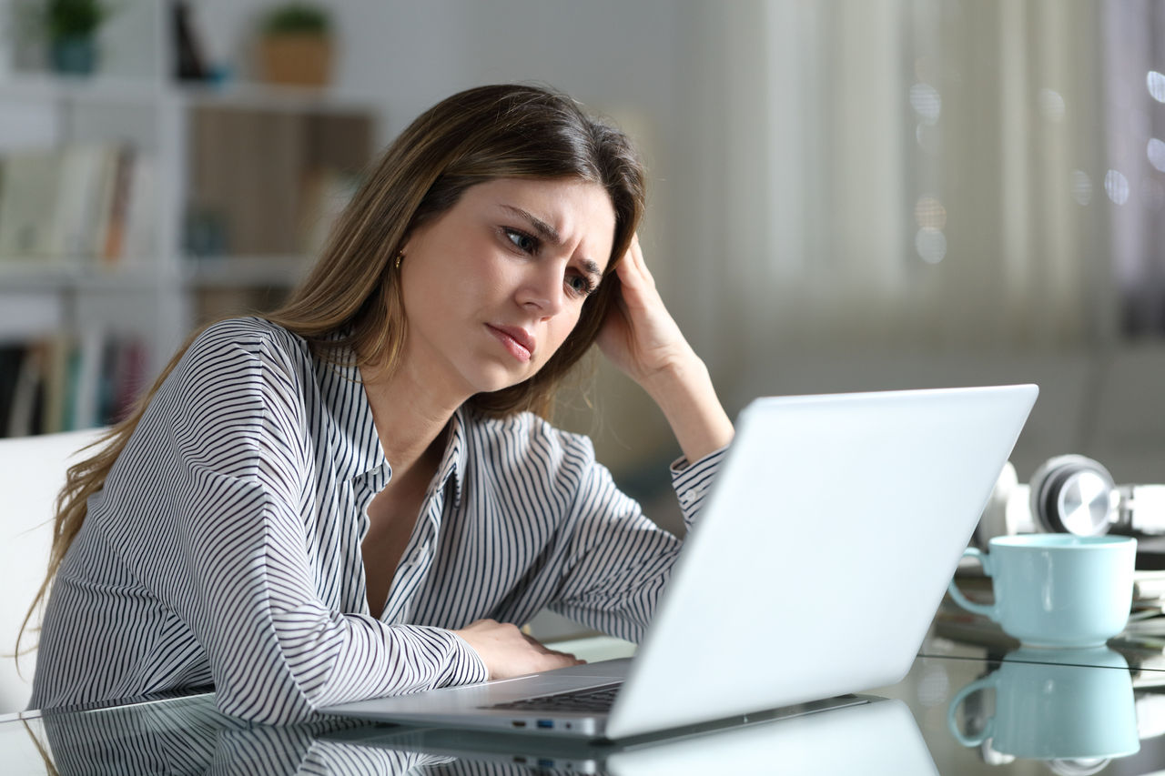 Frustrated woman reads email on her laptop
