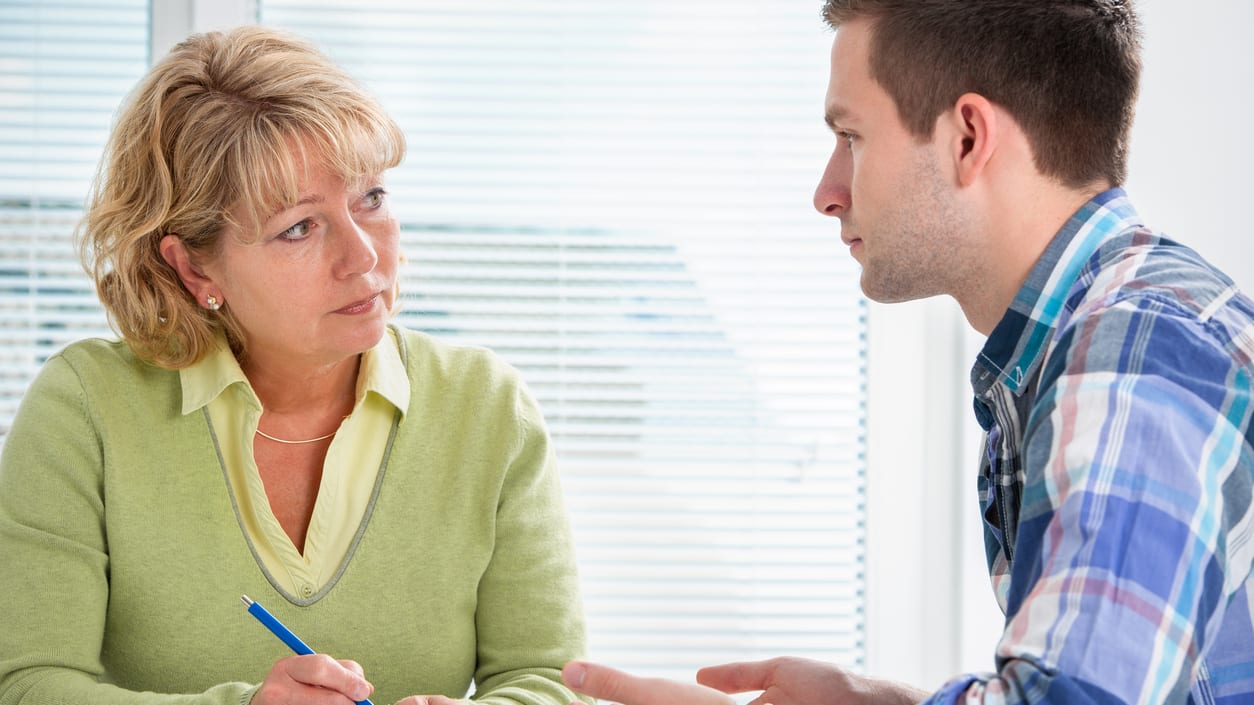 A woman talking to a man in an office.