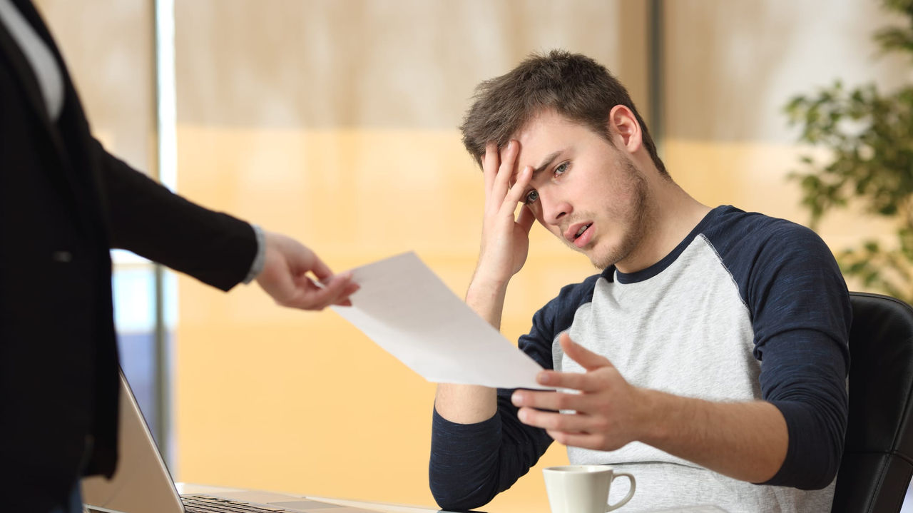 A man is holding a piece of paper in front of a woman.