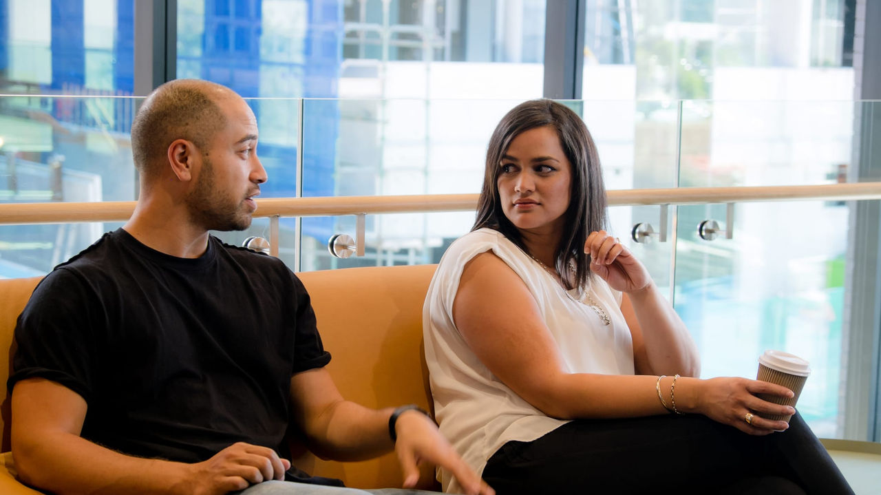 A group of people sitting on a couch in an office.