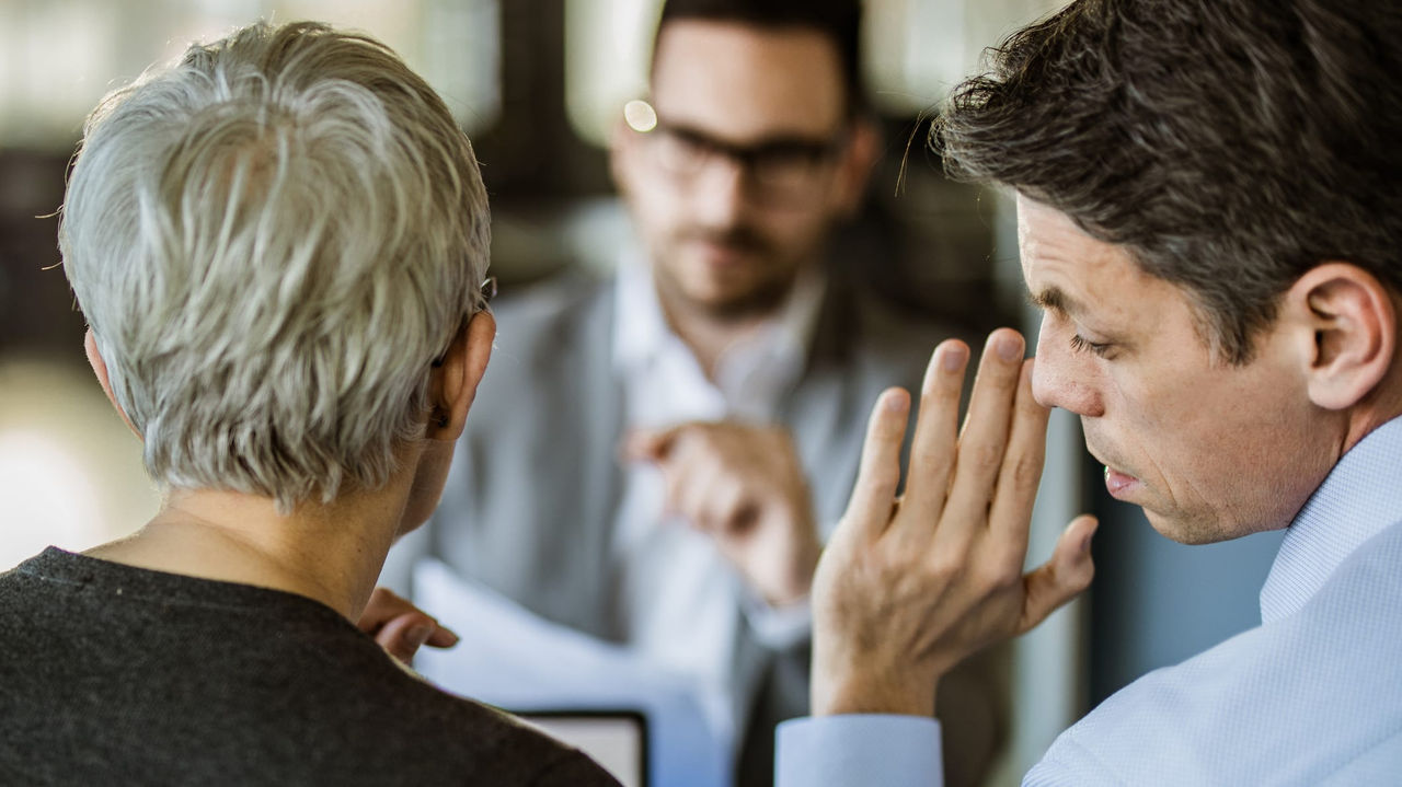 A man and woman are talking to each other in a meeting.