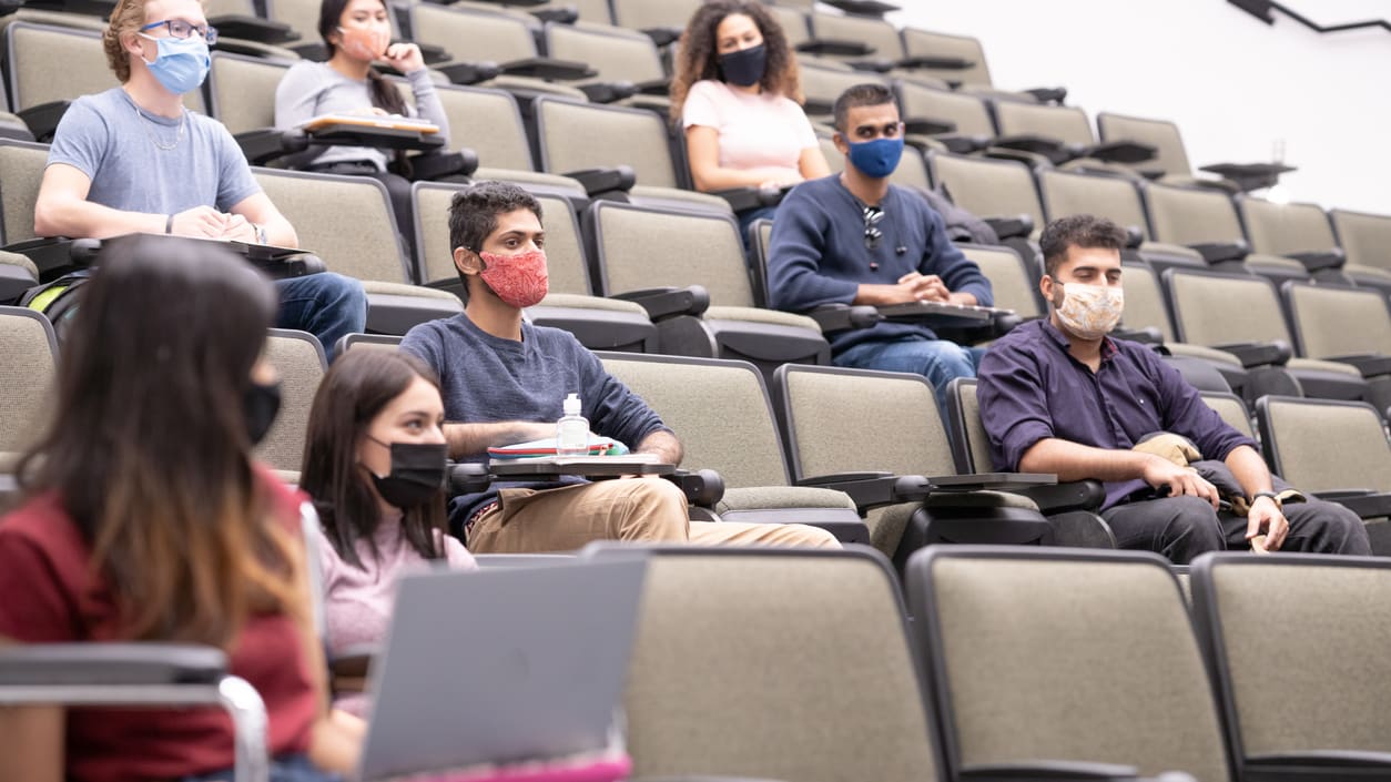 Students wearing face masks in a lecture hall.