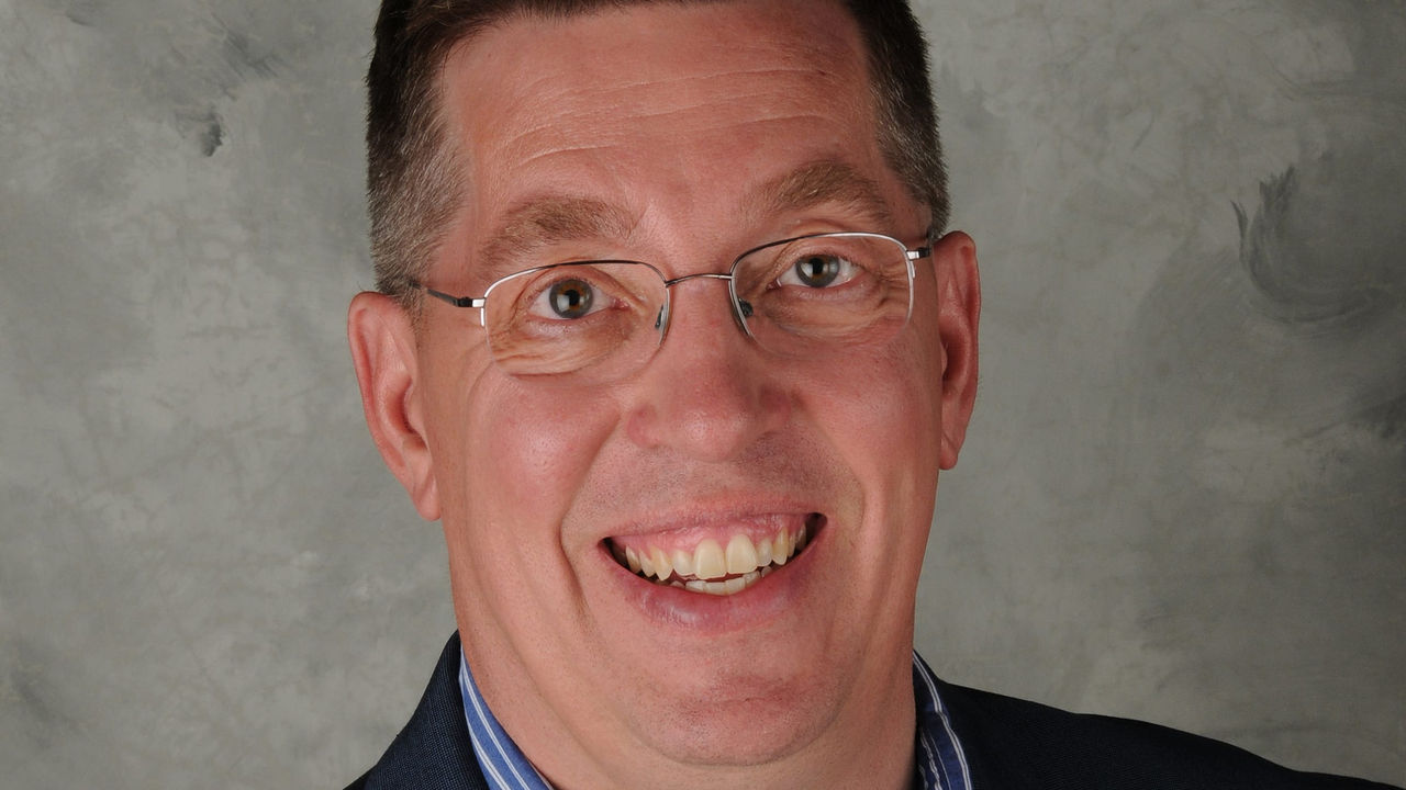 A man wearing glasses and a blue shirt.