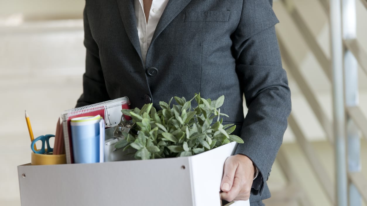 A business woman holding a box full of items.