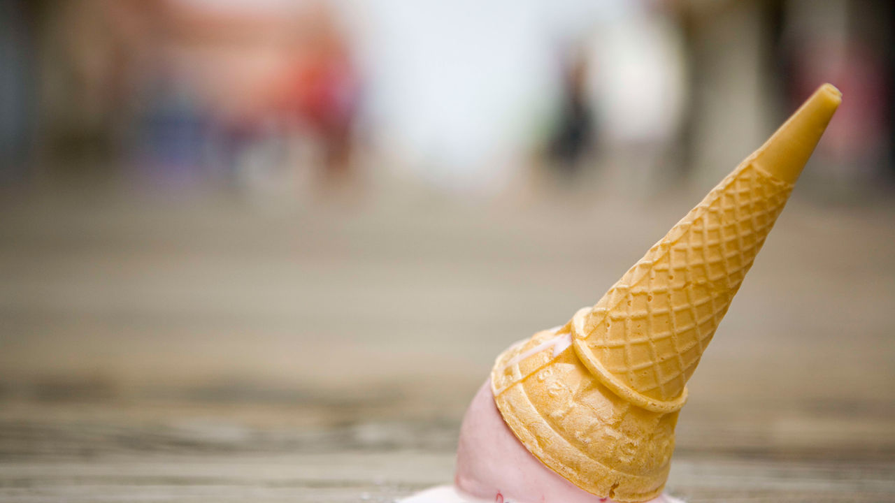 An ice cream cone sitting on a wooden board.