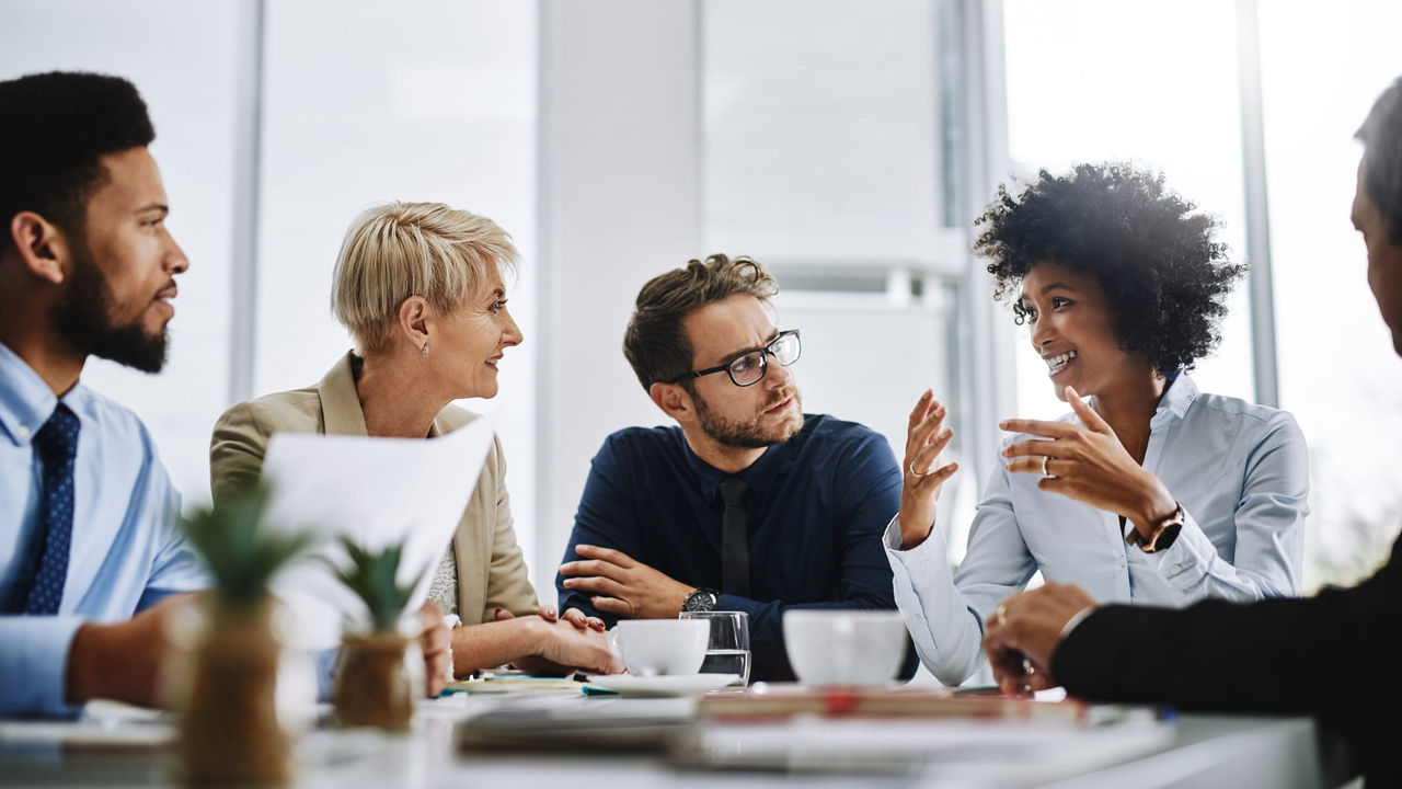 A group of business people talking at a meeting.