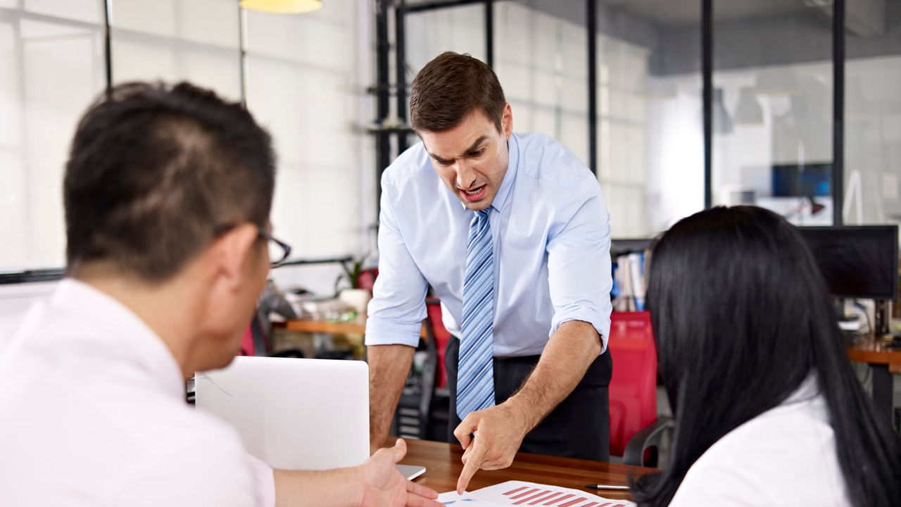 A group of people sitting around a table in an office.