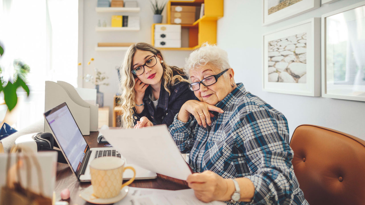 A woman and an older woman working at a desk.