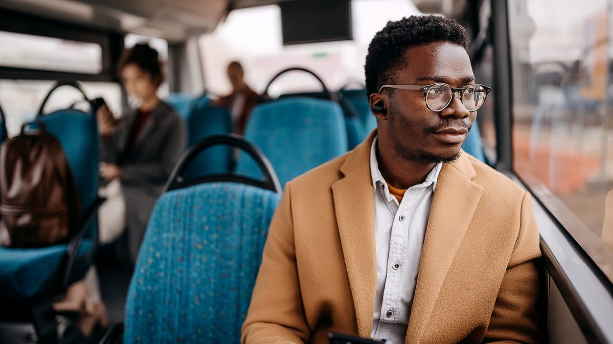 A man on a bus looking at his phone.