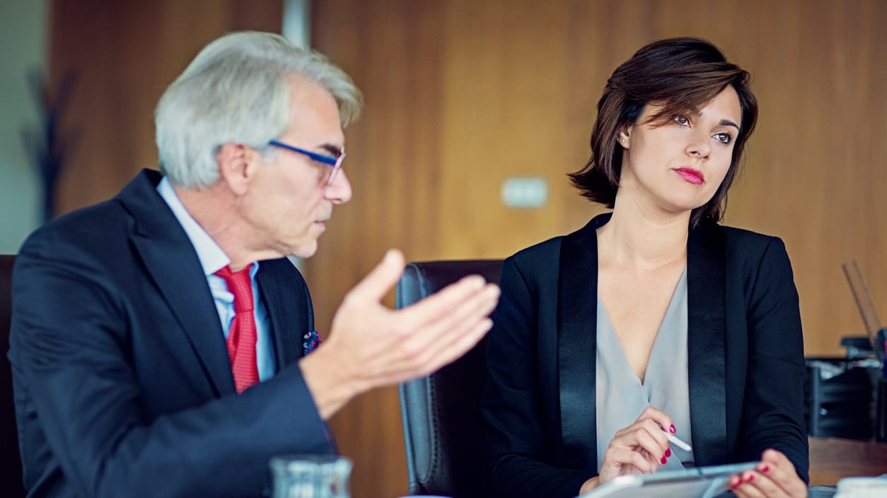 Two business people sitting at a conference table.