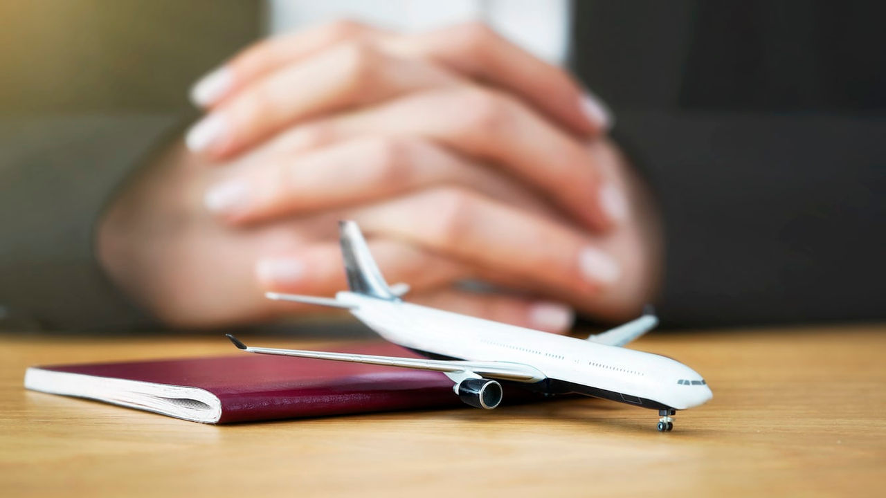 A small airplane sitting on a table next to a passport.