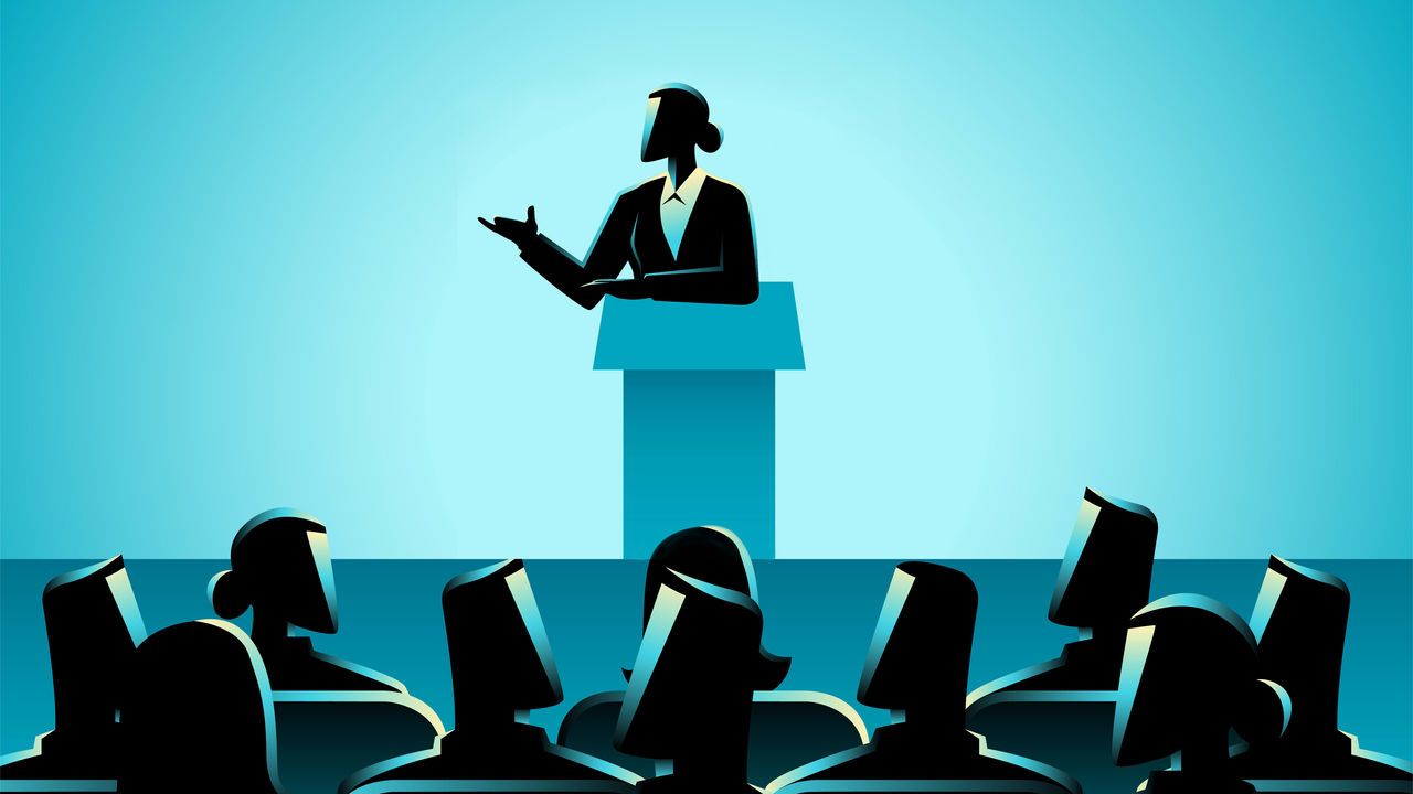 A silhouette of a man giving a speech to a group of people.