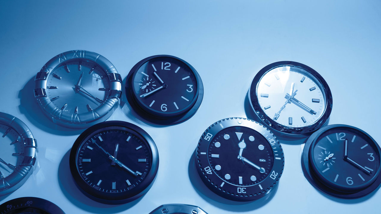 A group of clocks on a wall.