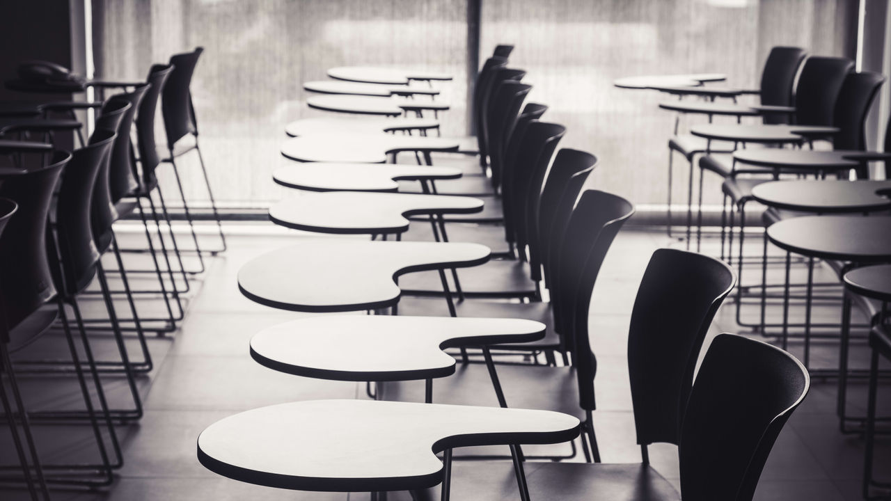 A row of empty chairs in a classroom.