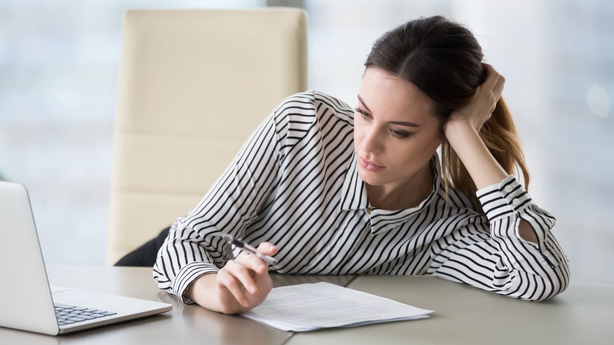 A woman sitting at a desk with a laptop.