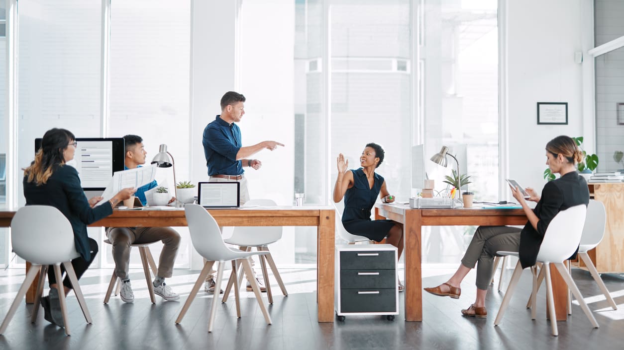 A group of people sitting around a table in an office.