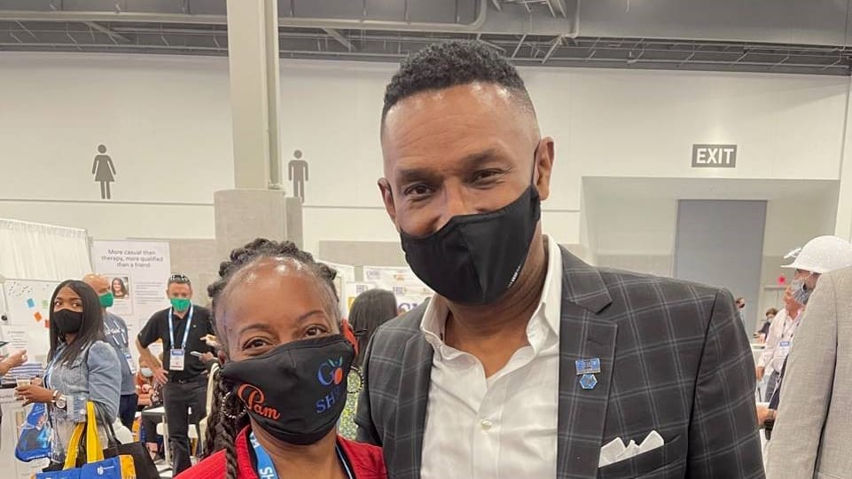 A man and woman wearing face masks at a convention.